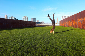 young woman making a handstand outside in a park