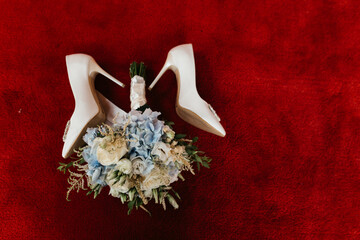 White Heels Filled With Flower Bouquet
On a red carpet, white heels with diamond stone details and a bouquet of beige and blue roses
