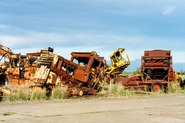 Abandoned old rusty rundown tractors agriculture machinery vehicles on disused RAF base runway on a cloudy day in England - obrazy, fototapety, plakaty