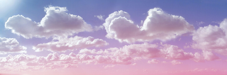 Beautiful cloud formation and sun shine - pink lilac blue sky and sun shining on big fluffy clouds providing a gorgeous summer cloudscape background with copy space ideal for holiday or spiritual them