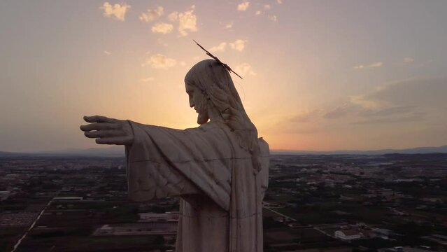 Statue of Jesus Christ Next to the sun at sunset.Cristo de Monteagudo, Murcia, Spain. aerial video