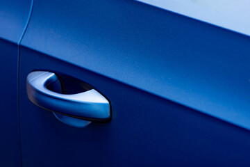 Close up to a metallic blue car door handle with shine - 548810343