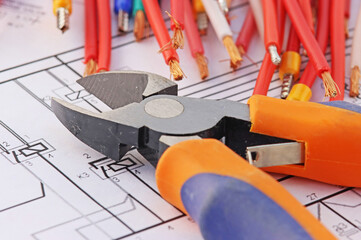 Electrical tools and copper insulated electrical cables. On an electronic diagram.