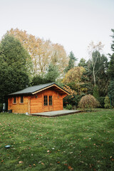 Beautiful forest hut for holidays in the forest. Garden shed with yellow leaves and trees in late autumn. Autumn mood in the country. 