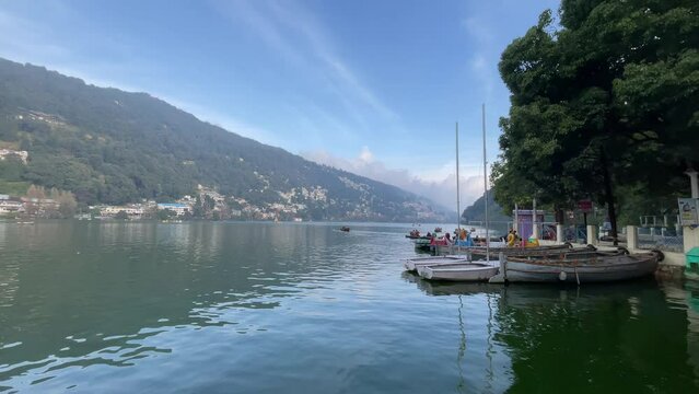 Boats flowing in Nainital (Naini) lake forested hill background Kumaon, Uttarakhand, India
