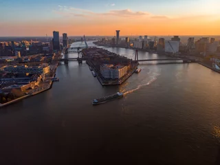 Papier Peint photo autocollant Pont Érasme Antenne d& 39 un navire sur une rivière avec un fond de pont Erasmus et d& 39 horizon de Rotterdam pendant le coucher du soleil