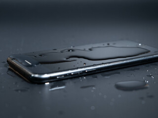 Close-up of an old telephone in water on a black background.