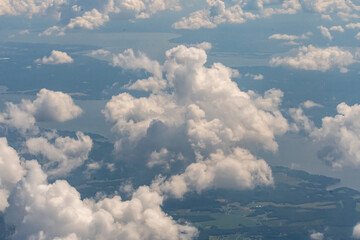 Aerial view of puffy white clouds from an airplane window at a comfortable cruising altitude 