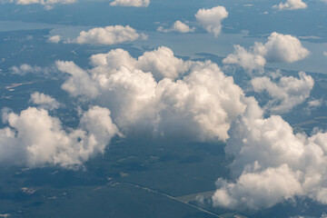 Fototapeta na wymiar Aerial view of puffy white clouds from an airplane window at a comfortable cruising altitude 