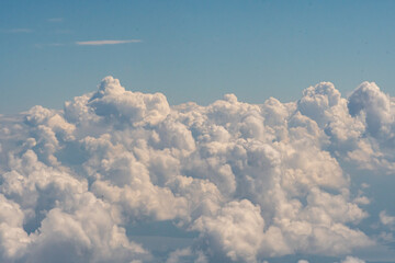 Fototapeta premium Aerial view of puffy white clouds from an airplane window at a comfortable cruising altitude 