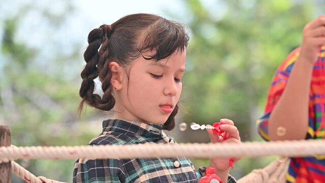 Group Asian kids girl are happy blowing soap im playground spring summer