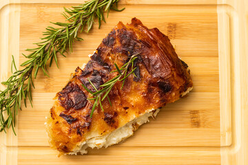 Homemade cheese pie, one piece on cutting board