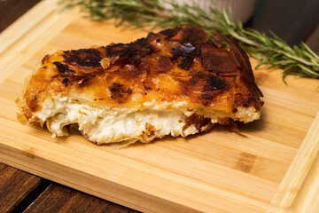 Homemade cheese pie, one piece on cutting board