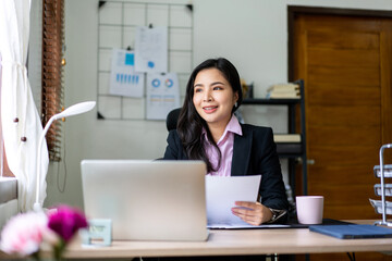 Young businesswoman in suit is holding business document and looking outside the window to resting after