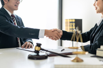 Female lawyer shaking hands with client after discussing deal of agreement together and signing contract