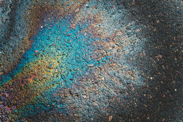 Oil stains on wet asphalt. The concept of environmental pollution, oil spills and environmental problems.