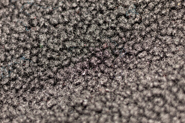 Close up on a warm and cozy woolen black fabric with a defocused part in the foreground