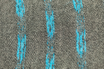 Fototapeta na wymiar Close up of a soft gray fabric with blue worn stripes