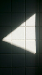 Triángulo de luz en pared de azulejo blanco