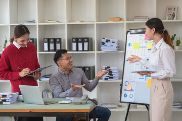 Fototapeta premium A team of businessmen plan with their laptops and graph charts for their profits and use a calculator to calculate their company's annual balance.