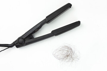 Women with hair loss problems. There are many hair fall out Black hair straightener with black hair on white background.