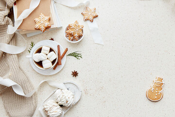 Aesthetics Christmas background with cup of hot drink, marshmallows, ginger snowflakes cookies, cinnamon sticks and books at cozy home flat lay. Copy space