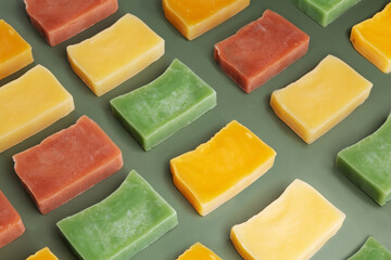 Pattern of eco-friendly natural soaps with various additives on a green background