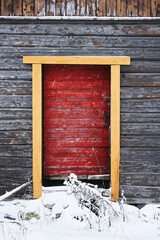 old red wooden barn door in winter