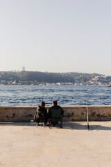 Two men fishing conversation and rest in beylerbeyi Istanbul, turkey