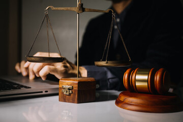 Business and lawyers discussing contract papers with brass scale on desk in office. Law, legal services, advice, justice and law concept