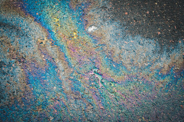 An oily iridescent stain of gasoline or oil spilled on the road.