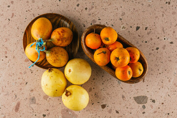 Winter season fruit in Mexico, Tejocotes on a wooden bowl, mucus grenades on a wooden plate and...