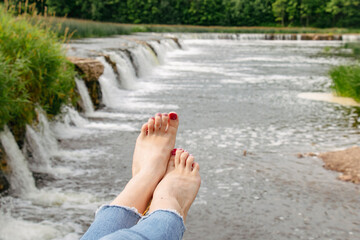 The beautiful Rumba waterfall is a waterfall on the Venta River in Kuldiga, Latvia. Girl on vacation