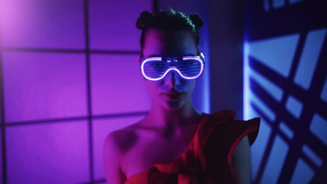 Portrait Asian fashion woman in illuminated eyeglasses posing at party night club discotheque light