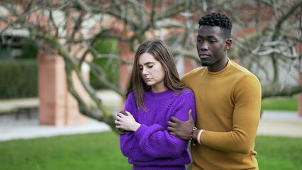 Fototapeta premium Boyfriend consoling depressed girlfriend. Partner calming girl walking together at park