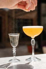 Cocktail making process. Bartender squeezes lemon zest.
