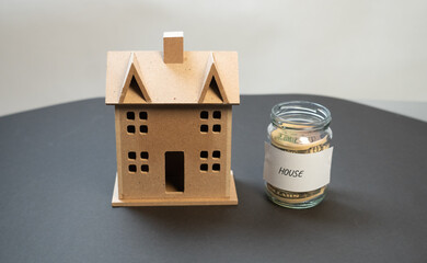 Jar of money (savings), home loan, money saving for a house in a glass jar, financial investment, house miniature