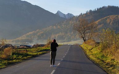 Female photographer taking photos while traveling in the Tatra Mountains in Slovakia.