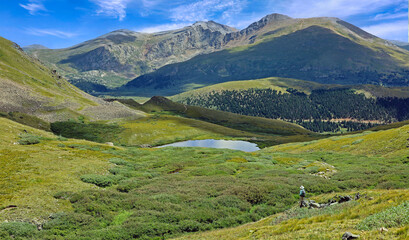 Fototapeta na wymiar Hiker on Colorado's Squaretop Lakes trail off Guanella Pass, with Mount Bierstadt in the background