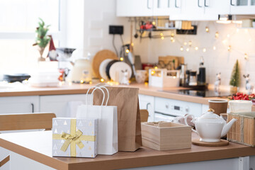 Gift box and packages are on kitchen table decorated for Christmas. Present and ready meals are delivered and prepared for the new year