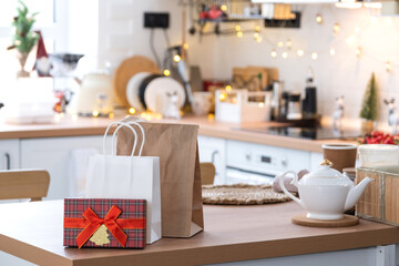 Gift box and packages are on kitchen table decorated for Christmas. Present and ready meals are delivered and prepared for the new year