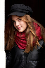 girl in a black cap with a red scarf close-up portrait