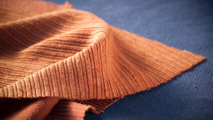 Corte de tejido de pana marrón sobre textil azul