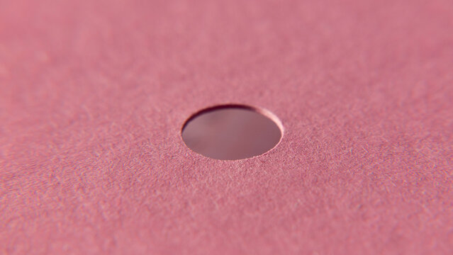 Agujero redondo en cart&oacute;n rosa de carpeta