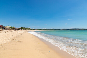 Fototapeta na wymiar Jimbaran beach with famous fish restaurants in sunny day with blue sky.