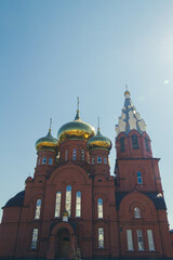 Fototapeta na wymiar Christian church against blue sky in bright sunlight. Church with dome.