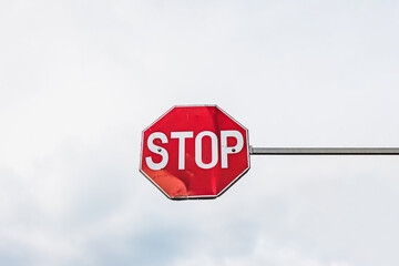 No entry or forbidden access or red stop sign on a pillar against a cloudy sky