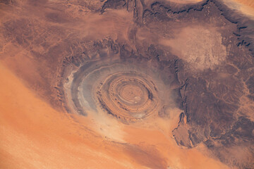 Aerial view of Richat Structure in Mauritania. Also called Guelb er Richât in Arabic Qalb ar-Rīšāt.  Digitally enhanced. The elements of this image furnished by NASA. - obrazy, fototapety, plakaty