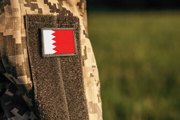 Close up millitary woman or man shoulder arm sleeve with Bahrain flag patch. Bahrain troops army,...