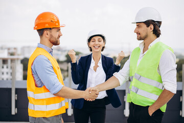 Business woman happy with architecs standing on the roof